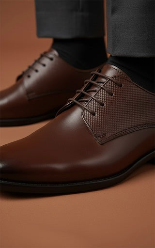 Brown leather dress shoes on a brown background