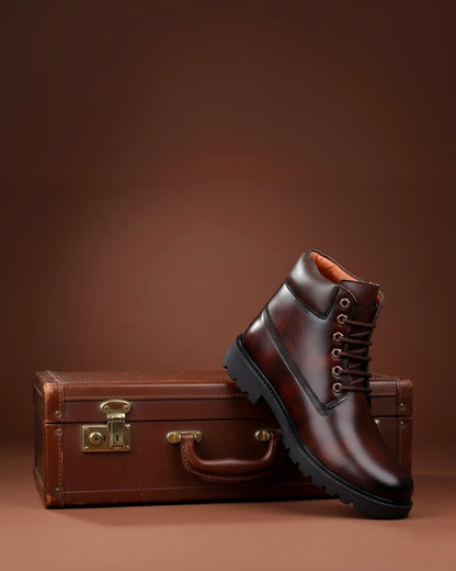 Brown leather boot and vintage suitcase on a brown background
