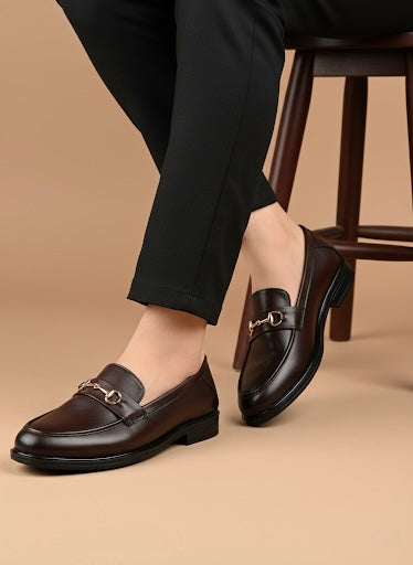 Person wearing black loafers on a beige background