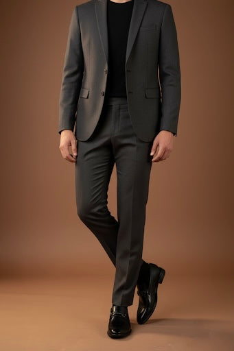 Man wearing a gray suit with black shoes on a brown background