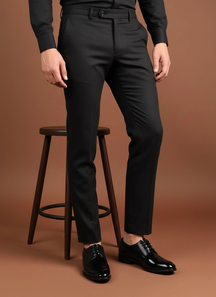 Person wearing black dress pants and shoes on a brown background