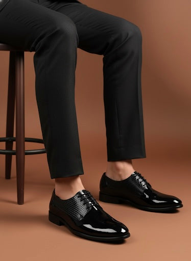 Person wearing black dress shoes and pants on a brown background