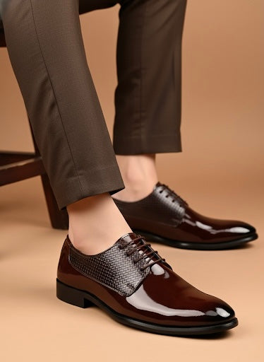 Brown dress shoes worn with gray pants on a beige background