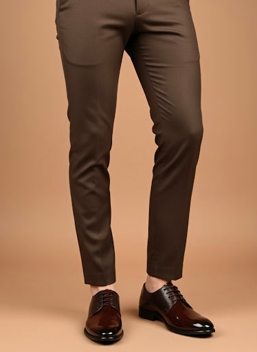 Brown suit pants with brown shoes on a beige background